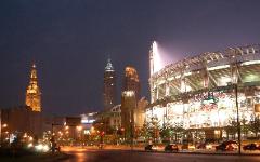 Photo at night of Jacobs Field (now Progressive Field) with downtown Cleveland, Ohio buildings behind.