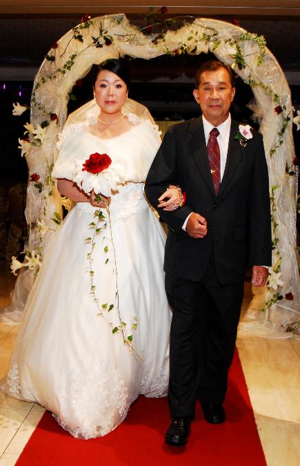 Asian bride and father walking down the aisle