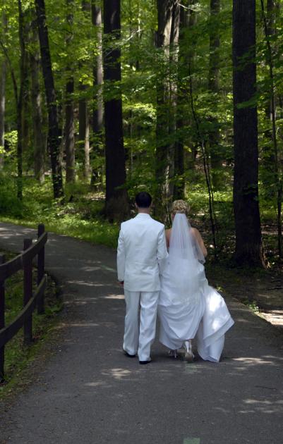 Bride and Groom walking down forest path